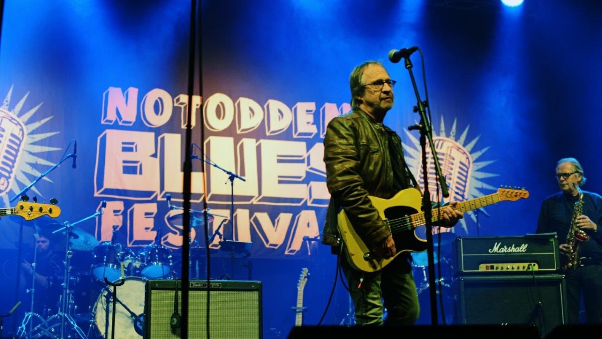 Gitarist på scenen på festival. Foto.